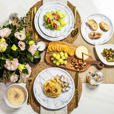 an assortment of cheeses, fruit and crackers on plates