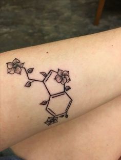 a woman's arm with a tattoo on it that has flowers growing out of it