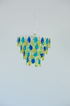 a chandelier hanging from a ceiling with blue, green and yellow glass beads