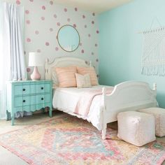 a bedroom decorated in pastel colors with polka dots on the walls and rugs