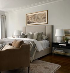 a large bed sitting next to two chairs in a bedroom