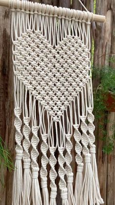 a white macrame hanging on a wooden fence