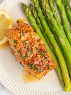 asparagus and salmon on a plate with lemon wedges