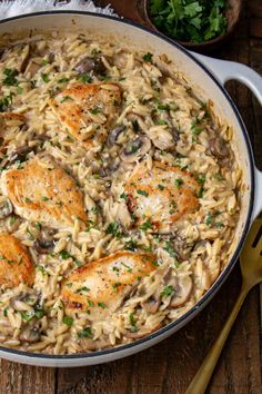 chicken and mushroom pasta in a skillet on a wooden table