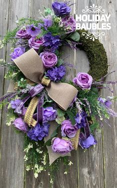 a wreath with purple flowers and green leaves