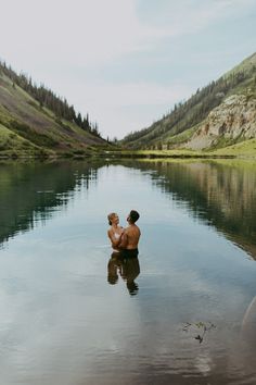 two people are sitting in the water with their backs to each other