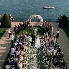 an aerial view of a wedding ceremony on the water