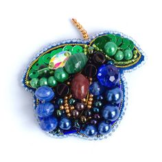 an apple ornament made out of glass beads and beadwork on a white background