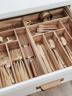 an open drawer filled with wooden utensils and spoons