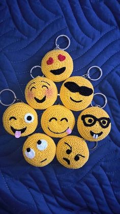 six yellow emoticive smiley face keychains on a blue quilt