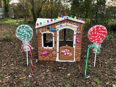 three candy canes are in front of a gingerbread house