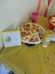 a table topped with lots of desserts next to a yellow table cloth covered table