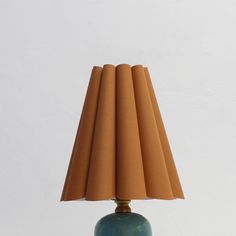 a lamp that is sitting on top of a table in front of a white wall