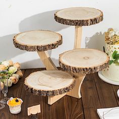 three tiered cake stand made out of wood slices on a wooden table with flowers in the background