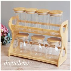 a wooden spice rack with four jars on it