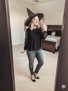 a woman wearing a witches hat taking a selfie