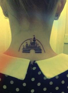 a woman's neck with a castle tattoo on it