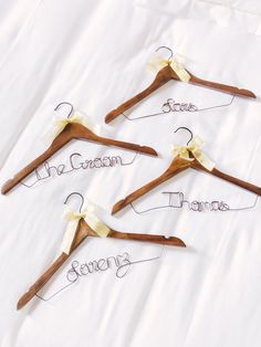 four wooden clothes hangers with the names of three different types of clothing on them