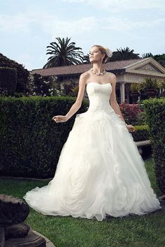 a woman in a wedding dress standing on the grass