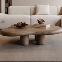 a wooden table sitting on top of a carpeted floor next to a white couch