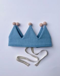 a pair of scissors are next to a blue hat with two small crowns on it