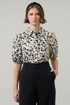 Add a nice touch to your wardrobe with the Jaleah Bubble Sleeve Button Up Blouse. Short bubble sleeves frame a collared neck with a button placket in the front. The fit maintains classic and fresh. Tuck in to high waisted pants for a classic look. - Bubble short sleeve- Button down - Classic fit- Cotton- Color: Ivory MultiSize + Fit - Model is 5'10" and wearing size XS- Measurements taken from size S - Chest: 19 3/4"- Length: 25" Fabric Self:100%cotton Style Number STT17426DR Puff Sleeve Shirt With Button Closure For Work, Puff Sleeve Blouse With Button Closure For Work, Floral Print Short Sleeve Blouse For Work, Short Sleeve Blouse With Floral Print For Work, Fall Short Sleeve Blouse With Button Cuffs, Fitted Blouse With Button Closure And Spread Collar, Semi-formal Collared Tops With Button Closure, Formal Puff Sleeve Top With Button Closure, Office Wear Shirt With Button Closure