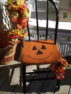 a wooden chair with a pumpkin face painted on it