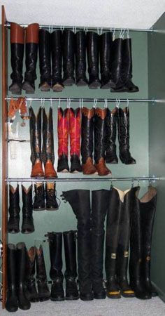 several pairs of boots are lined up on shelves