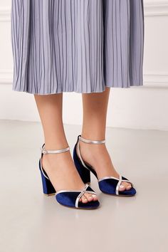 A chic addition to evening ensembles, our blue strappy block heels bring a touch of glamour, handcrafted from velvet and supple leather. Enhancing the allure of your feet, it features an elegant cross-design toe strap adorned with silver leather, creating a striking contrast against the velvet backdrop. A dainty ankle strap gracefully winds around the heel, fastening with a stylish buckle. These navy-blue block heel sandals stand confidently on a chunky heel, ensuring a perfect balance of stability and sophistication. Experience extra comfort and durability with the thick insole cushion, transforming each step into a luxurious journey. Isidora style dark blue block heels embodies elegance, where every detail is a tribute to the artistry of handmade craftsmanship. Wedding Shoes Blue, Velvet Backdrop, Sandals Low Heel, Flat Sandals Wedding, Blue Block Heels, Heels Blue, Blue Wedding Shoes, Strappy Block Heels, Wedding Shoes Flats