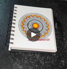 a spiral notebook with an orange design on it