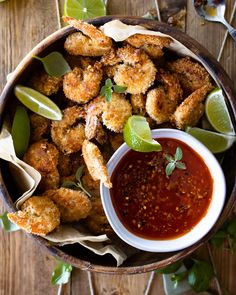 a wooden bowl filled with fried food and dipping sauce