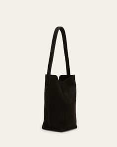 THE ROW "Park" northsouth tote bag in fine nubuck leather     Shoulder strap     Open top with magnetic closure     Approx. 8.6"H x 5.5"W x 5.1"D    Made in Italy Nubuck Leather, Black Tote Bag, The Row, Shoulder Strap, Tops Designs, Tote Bag, Luxury Fashion, Leather, Black