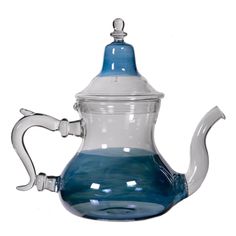 a blue glass tea pot with a white lid and handle on the top, sitting in front of a white background