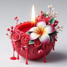 a candle that is sitting on top of a bowl with flowers and leaves in it