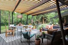 a covered patio with chairs, tables and potted plants on the decking area