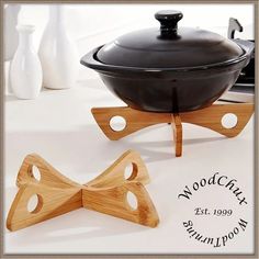 a wooden object sitting on top of a table next to a pot and saucer