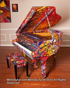 a colorful piano is sitting in the middle of a room