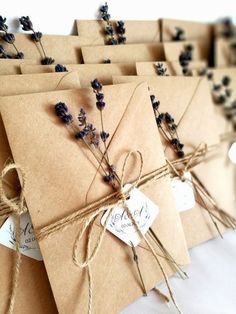 several brown envelopes tied with twine and some lavender flowers are on the table