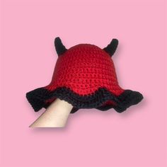 a crocheted red and black hat with horns