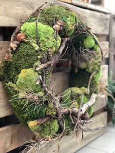 a moss covered wreath is sitting on a pallet