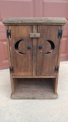 an old wooden cabinet with two doors on the front and one door open to reveal a hole in the side