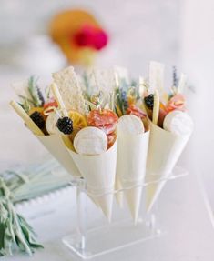 an arrangement of appetizers in cones on a table