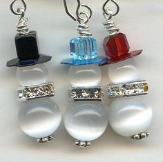 four different colored glass beaded hats hanging from silver earwires on white background