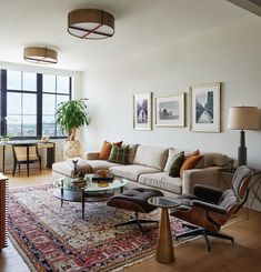 a living room filled with furniture and a large window covered in lots of natural light