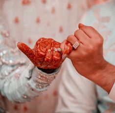 the bride and groom are holding their hands together with hendis painted on them