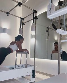 a woman is doing exercises in front of a mirror