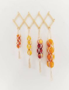 three macaroni and oranges hanging on a wall next to a wooden rack