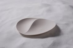 an empty white plate sitting on top of a bed