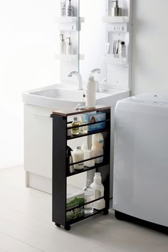 a white sink sitting next to a wooden cabinet filled with bottles and other bathroom items