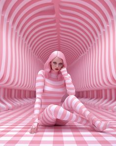 a woman sitting on the ground in a pink and white striped room